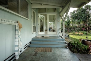 Step into a serene outdoor space with a covered porch leading to a residential entrance.