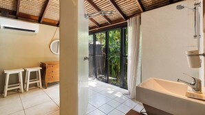 A bathroom with a large bathtub, a white sink, and a wooden vanity.