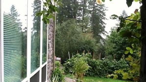 Een tuin met een stenen rand, verschillende planten en een gazon.