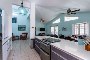 A spacious kitchen with a central island, a ceiling fan, and a dining area with a table and chairs.