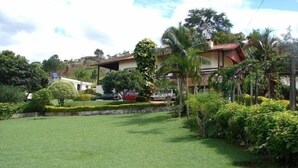 A well-maintained lawn with a few trees and a building in the background. - House with 5 bedrooms, beautiful view of Pedra Grande. (Atibaia)