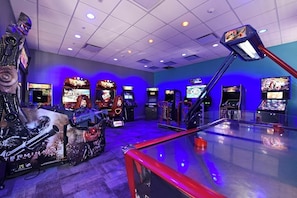 Um salão de jogos com várias máquinas, incluindo uma máquina temática de Terminator em destaque.