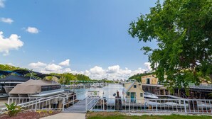 A marina with boats docked, a small building, and a pathway leading to the water.