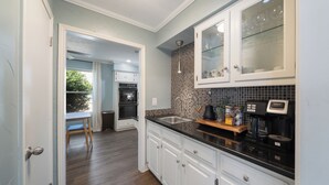 A modern kitchen with white cabinets, a black countertop, and a tiled backsplash. - Family Dream Home, Arcade fun!, Huge Pool! 5 bedrooms, 3 baths  (Plano)