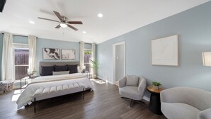 A bedroom with a bed, two chairs, a ceiling fan, and artwork on the walls. - Family Dream Home, Arcade fun!, Huge Pool! 5 bedrooms, 3 baths  (Plano)