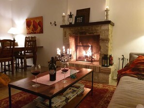 A cozy living room with a stone fireplace, a dining area with wooden furniture, and a painting on the wall. - Luxury Farmhouse With Pool Close To The Sea (Palmoli)