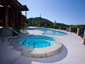 A pool area with a hot tub, stone steps, and a wooden deck. - Less Than 1 Mile From The Parkway With Full Resort Amenities (Pigeon Forge)