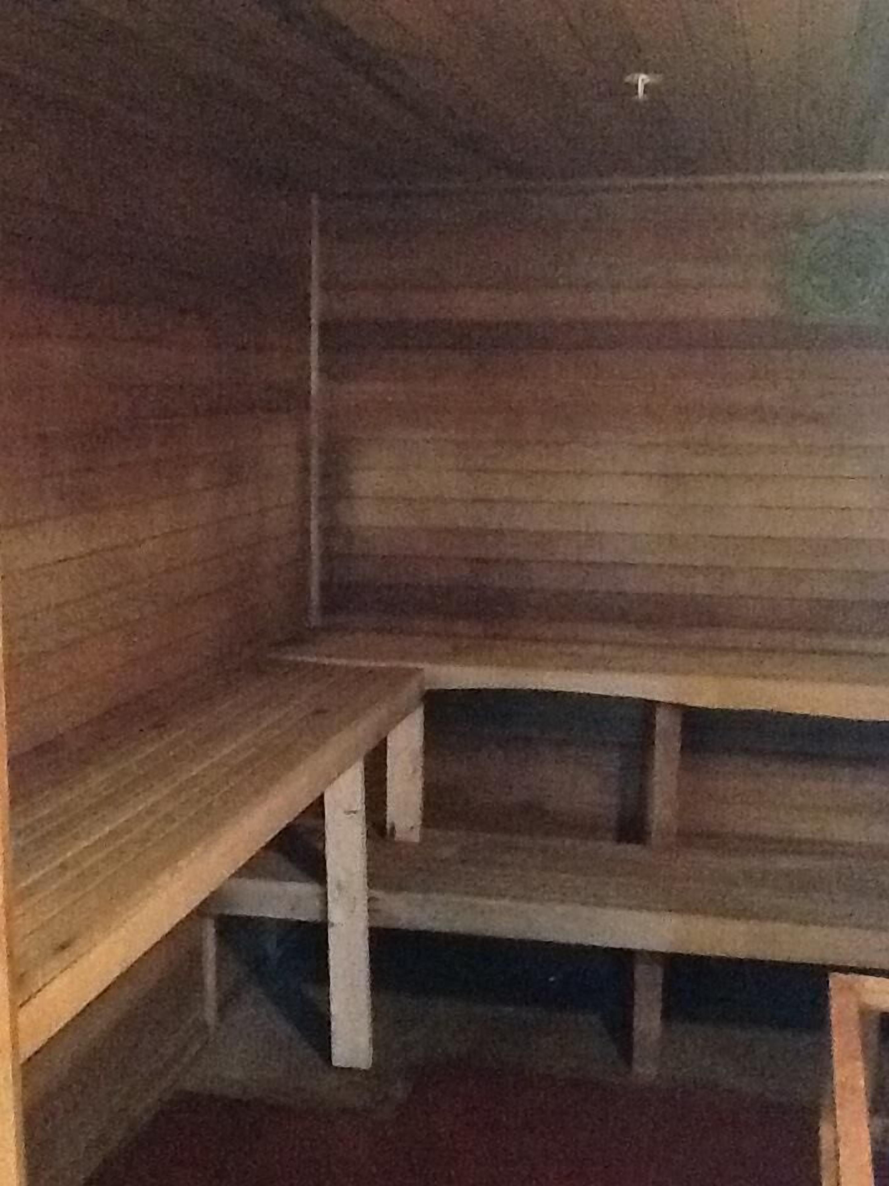 Interior de madera con bancos y techo bajo.