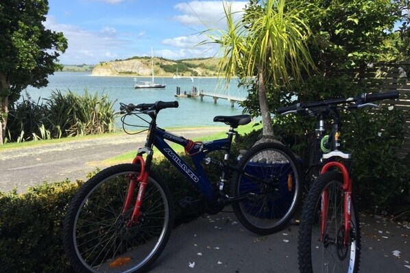 Un vélo est garé au bord de l’eau, offrant une vue sur les bateaux et un quai.