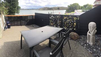 An outdoor seating area with a table and chairs, a decorative fence, and a statue.