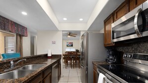 A modern kitchen with granite countertops, stainless steel appliances, and wooden cabinets.