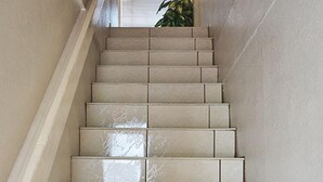 A staircase with a handrail, leading upwards.
