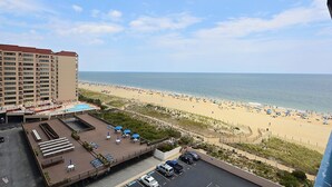 Un hotel con terrazza sul tetto, piscina e vista sulla spiaggia.