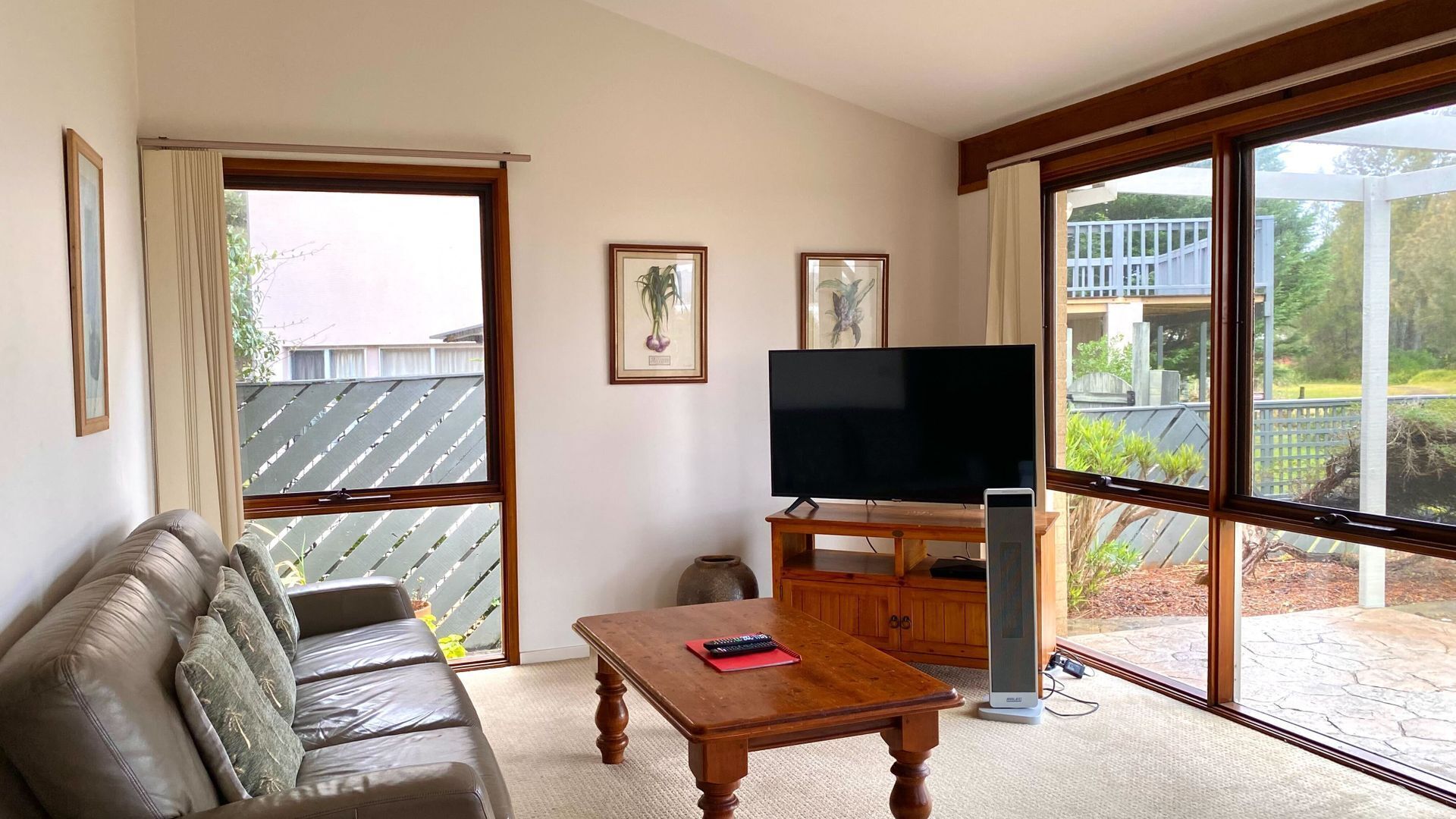 A living room with a sofa, a coffee table, a TV, and a large window.