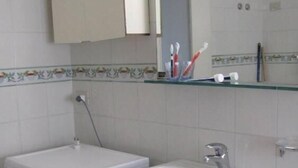 A compact bathroom with a washing machine, a sink, and a toilet. - Charming historical 4 guests apartment stunning sea view free wi- fi parking  (Monterosso al Mare)