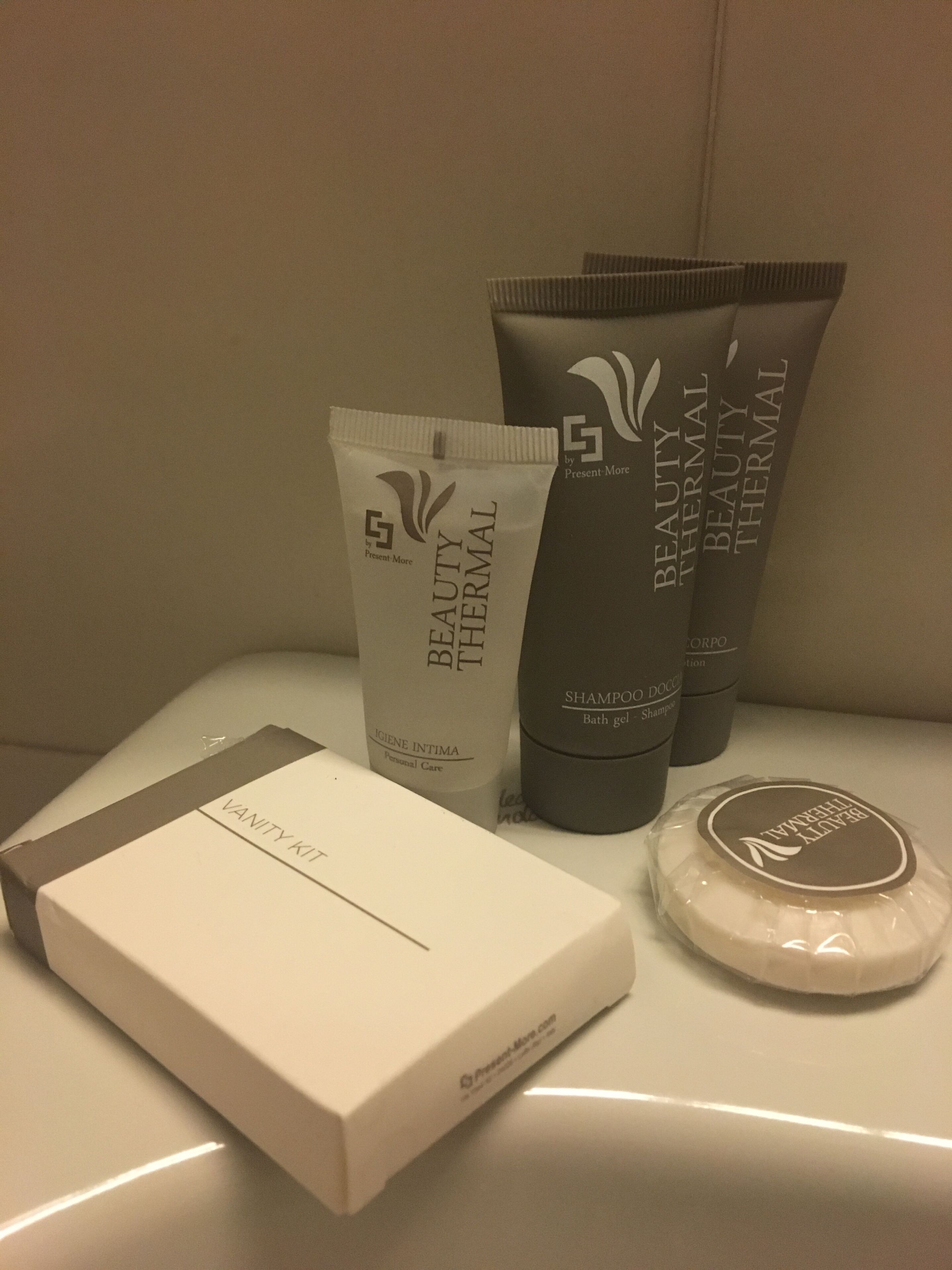 A vanity kit with a box, a tube of body lotion, and two bottles of shampoo.
