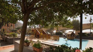 A playground with a slide and climbing structures, a pool, and surrounding landscaping. - Charming historical 4 guests apartment stunning sea view free wi- fi parking  (Monterosso al Mare)