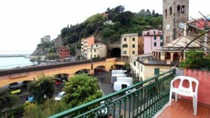 A coastal town with a prominent tower, colorful buildings, and a bridge leading to the sea. - Charming historical 4 guests apartment stunning sea view free wi- fi parking  (Monterosso al Mare)