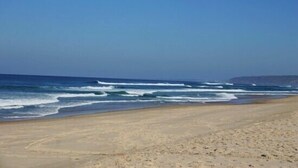Ein Strand mit Wellen und blauem Himmel.
