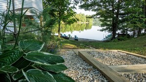 Un entorno tranquilo junto al lago, con muelle de madera, piedras y abundante vegetación.