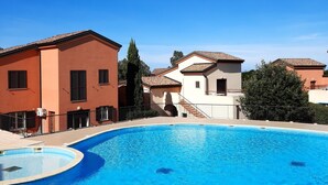 A swimming pool with a curved edge, surrounded by a metal fence. - Quiet 500 m from Lozari beach (Palasca)