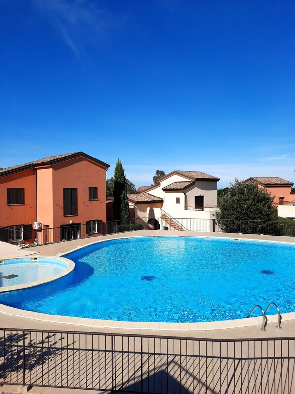 A swimming pool with a curved edge, surrounded by a metal fence. - Quiet 500 m from Lozari beach (Palasca)