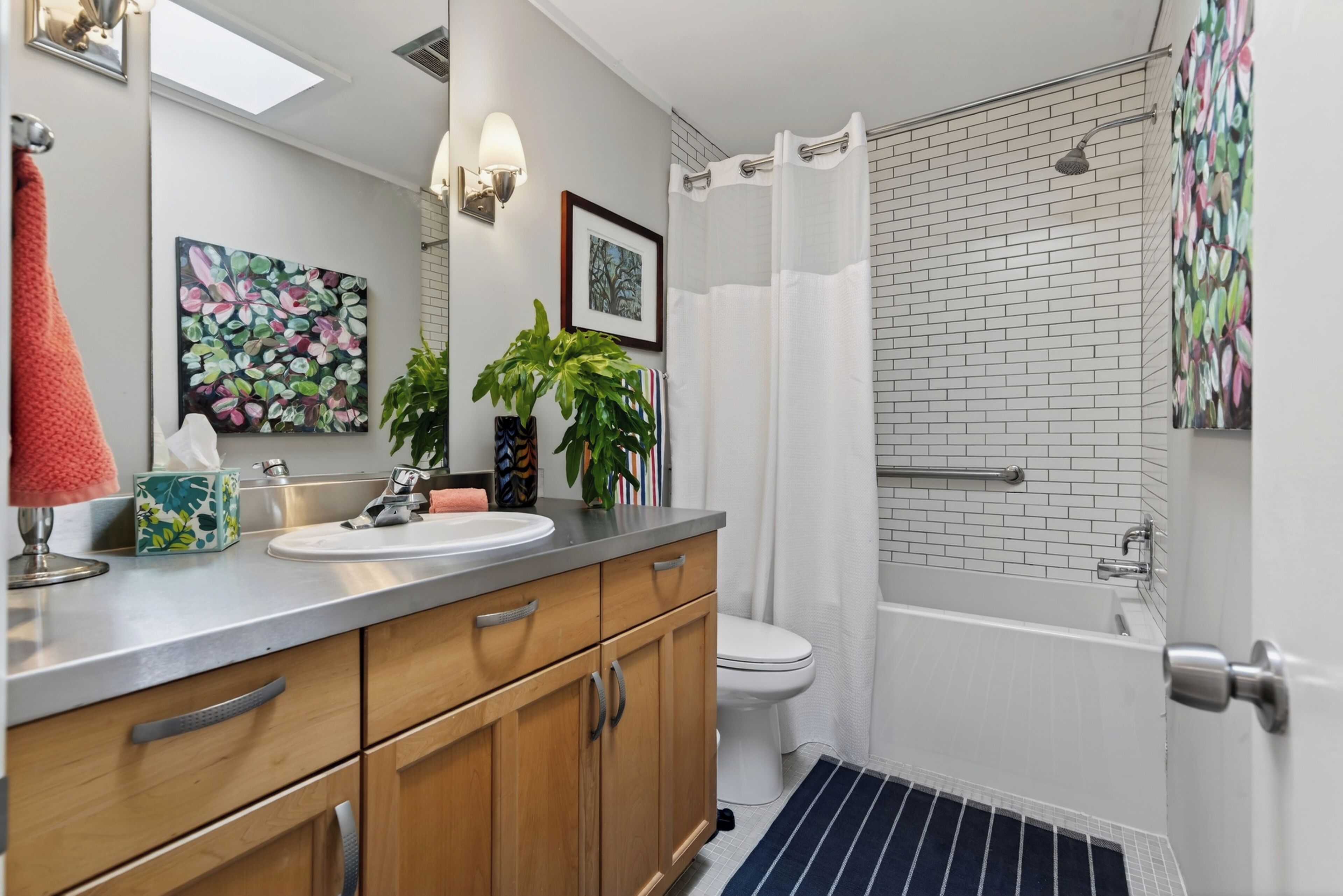 A bathroom with a sink, toilet, shower, and a towel rack.