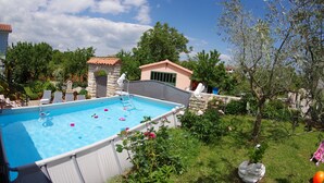 A backyard with a swimming pool, surrounded by greenery and a small building. - Countryside Holiday Apartment In Village Peresiji (Peresiji)