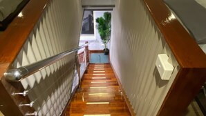 A narrow staircase connecting two rooms with wooden flooring and metal railings. - Hawkesbury River Guest House (Lower Portland)