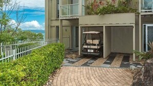 Ein modernes, mehrgeschossiges Gebäude mit überdachter Parkgarage und Golfwagen.