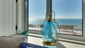 Une pièce dotée d’une grande fenêtre donnant sur la mer.