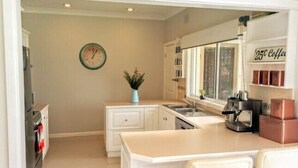 Una cocina moderna con una isla central, una cafetera y un reloj en la pared.