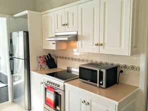 Effortlessly prepare meals in this well-equipped kitchen with a refrigerator, oven, and toaster oven.