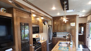 A modern kitchen with wooden cabinets, stainless steel appliances, and a central island. - Ocean Front with Dock, Key Largo, FL., Pirate's Cove (Key Largo)