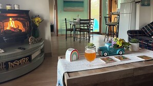 Una sala de estar acogedora con chimenea, un comedor y una cocina.