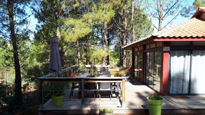 A wooden deck with outdoor furniture, a hammock, and potted plants. - Vacation home under the pines (moliets et maa)