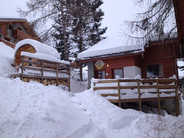 A wooden cabin with a snow-covered roof and a wooden fence. - La Plagne / Les Coches Ski-in / Ski-out chalet on the slopes, free wifi and sauna !! (La Plagne Tarentaise)