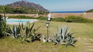 A pool area with a mountain in the background, surrounded by greenery and a clear sky. - Beachfront villa private pool   (Tertenia Marina di Tertenia)