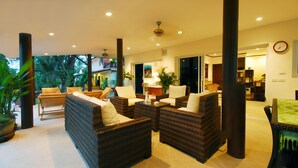 A spacious living area with wicker furniture, a coffee table, and a view of the outdoors. - Beachfront Resort: Villa 4-bdr, very spacious, only 20m to the beach. (Maenam)