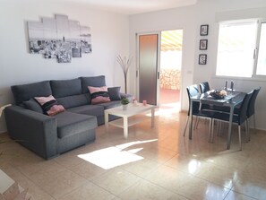 Relax in this stylish living space with a comfortable sofa, dining table, and potted plant.