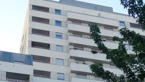 A multi-story building with a modern architectural design, featuring a grid-like facade and balconies.