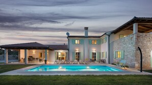 A two-story house with a swimming pool, outdoor seating, and a stone wall. - Villa Roko  in Vodnjan (Vodnjan)