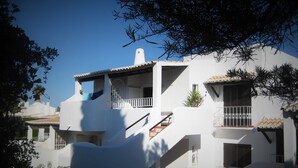 A white building with multiple balconies, a staircase, and a small garden area. - Lovely Spacious Apartment Facing South With Sea Views with use of  communal pool (Sesmarias)