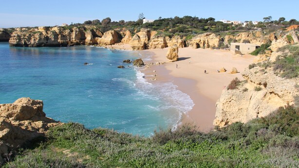 A coastal beach with rocky cliffs, clear blue water, and a sandy shore. - Lovely Spacious Apartment Facing South With Sea Views with use of  communal pool (Sesmarias)