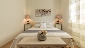 Ein ordentlich eingerichtetes Schlafzimmer mit Bett, Nachttischen, einer dekorativen Vase und einem Wandbild.