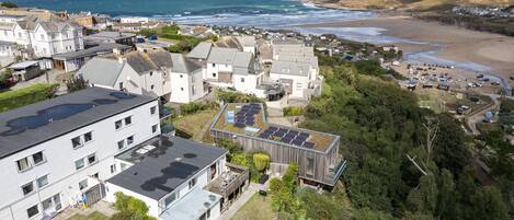 Un quartier résidentiel situé sur la côte, avec des maisons, une plage et une vue sur la mer.