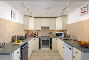 A compact kitchen with white cabinets, a microwave, a toaster, and a sink.