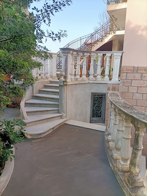 Un escalier avec des balustrades en pierre menant à un balcon.