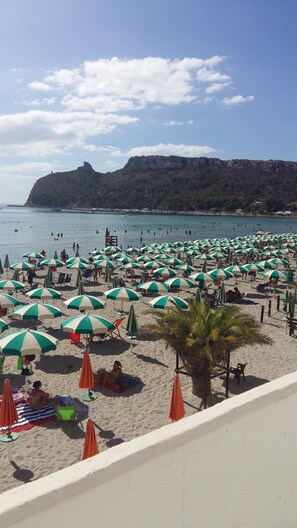 A beach with numerous umbrellas and people.