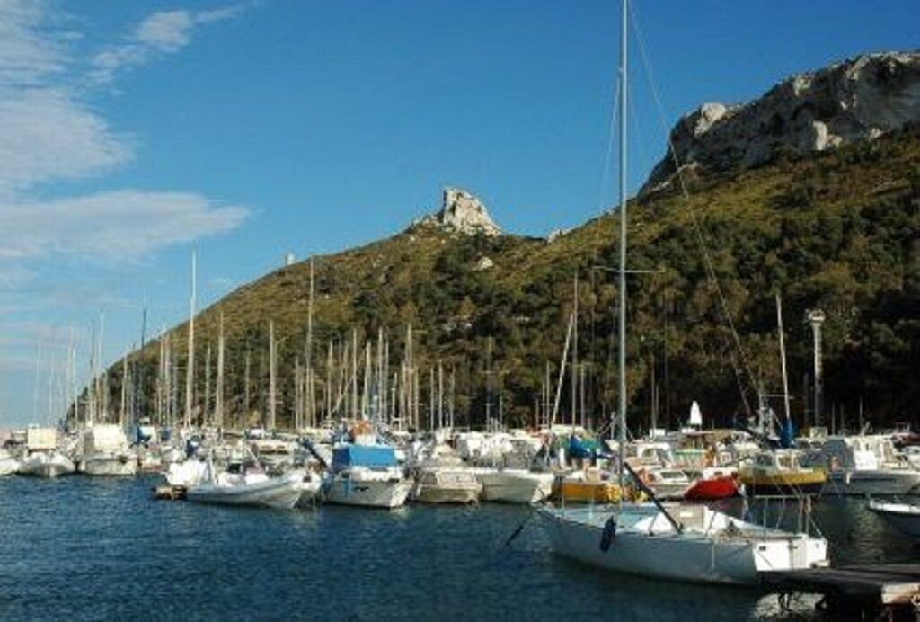 Un port de plaisance où des bateaux sont amarrés le long d’une colline.